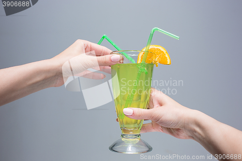 Image of The female hands with cocktail on gray background