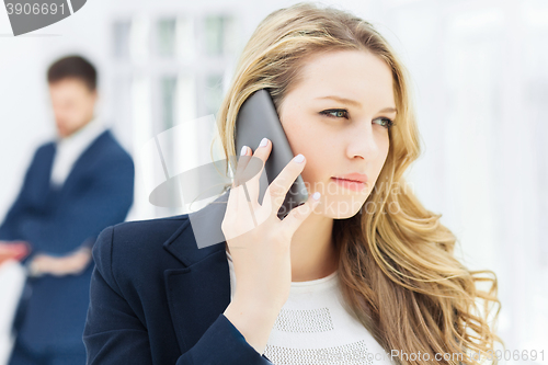 Image of Portrait of businesswoman talking on phone in office