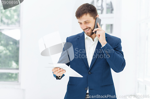 Image of Portrait of businessman talking on phone in office