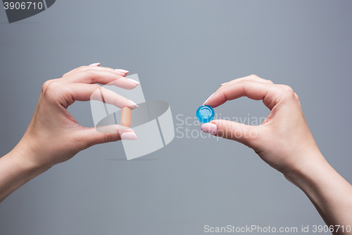 Image of The female hands with sweet candy and pills 