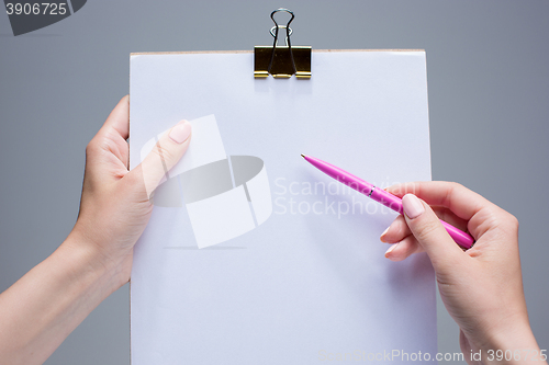 Image of The notepad and pen in female hands