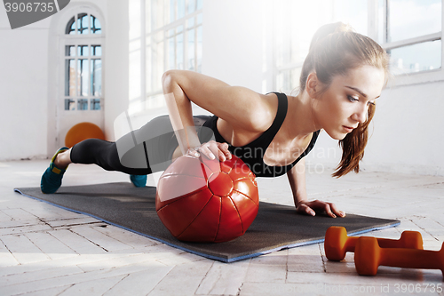 Image of Beautiful slim brunette doing some gymnastics at the gym