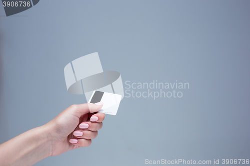 Image of The card in a female hand is on a gray background