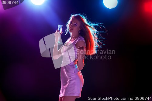 Image of The beautiful girl dancing at the party drinking champagne