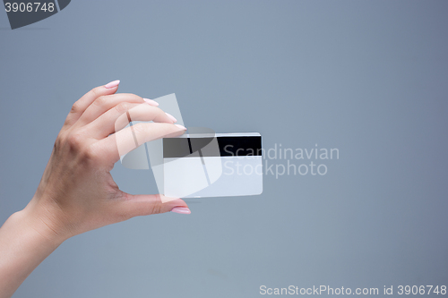 Image of The card in a female hand is on a gray background