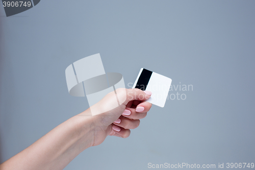 Image of The card in a female hand is on a gray background