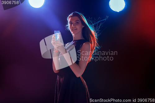 Image of The beautiful girl dancing at the party drinking champagne