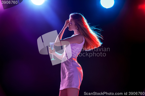 Image of The beautiful girl dancing at the party drinking champagne