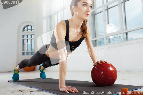 Image of Beautiful slim brunette doing some gymnastics at the gym