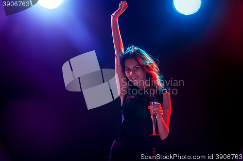 Image of The beautiful girl dancing at the party drinking champagne