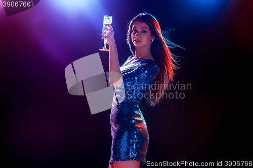Image of The beautiful girl dancing at the party drinking champagne
