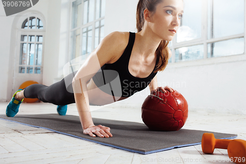 Image of Beautiful slim brunette doing some gymnastics at the gym