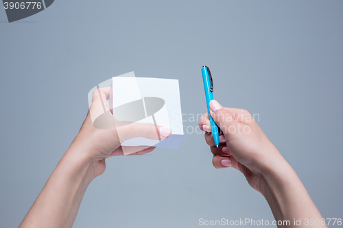 Image of The notepad and pen in female hands