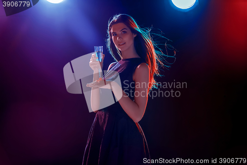 Image of The beautiful girl dancing at the party drinking champagne