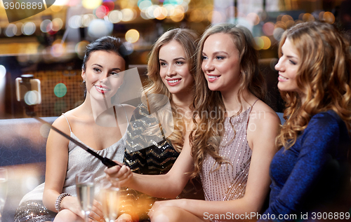 Image of women with smartphone taking selfie at night club