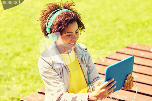 Image of happy african woman in headphones with tablet pc