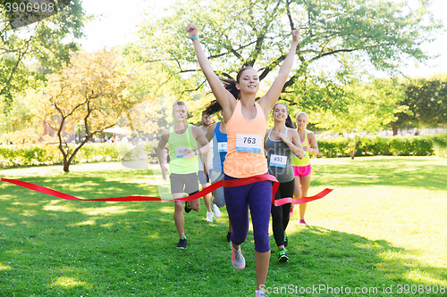 Image of happy young female runner winning on race finish