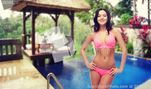 Image of happy young woman in pink bikini swimsuit