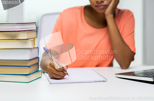 Image of close up of woman with laptop and books at home