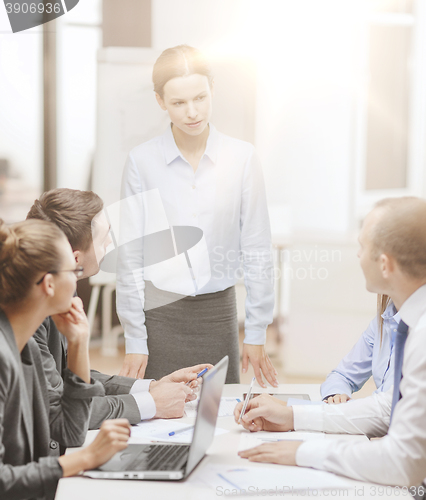 Image of strict female boss talking to business team