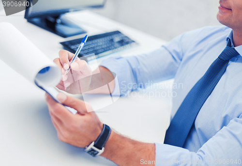 Image of businessman working and signing papers