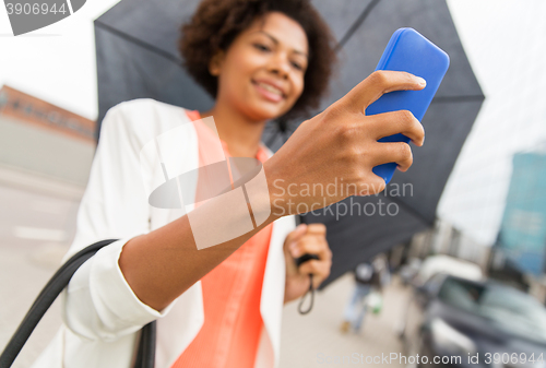 Image of close up of woman with umbrella and smartphone