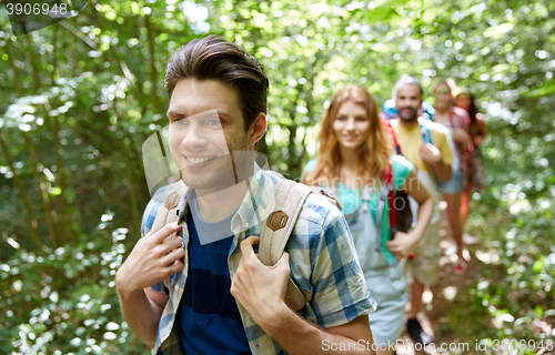 Image of group of smiling friends with backpacks hiking