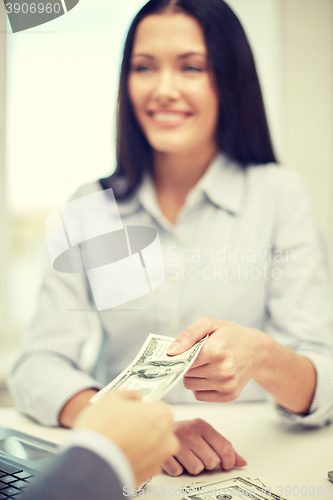 Image of close up of happy woman giving or exchanging money