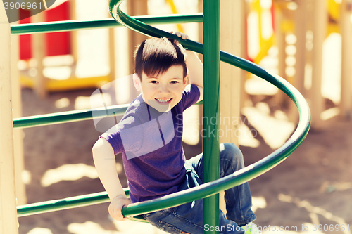 Image of happy little boy climbing on children playground