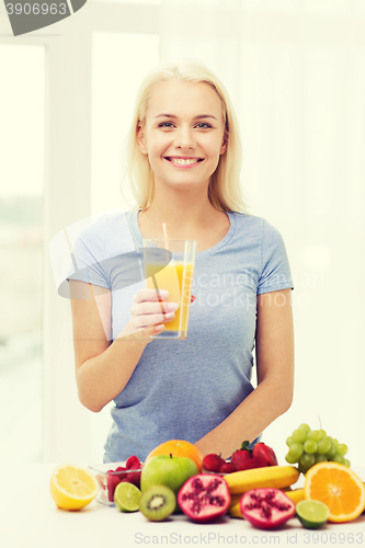 Image of smiling woman drinking fruit juice at home