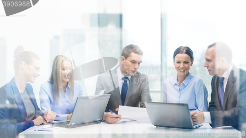 Image of business team with laptop having discussion