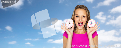 Image of happy woman or teen girl with donuts