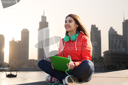 Image of happy young woman with tablet pc and headphones