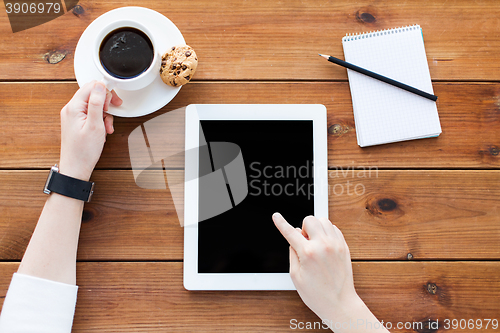 Image of close up of woman with tablet pc on wooden table