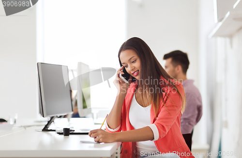 Image of businesswoman calling on smartphone at office