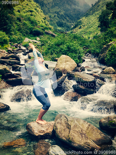 Image of Sorty fit woman doing yoga asana Utkatasana outdoors