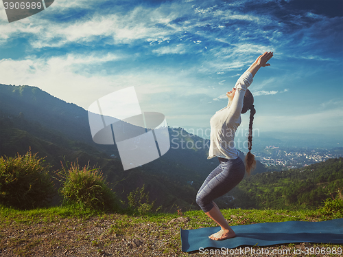 Image of Woman doing yoga asana Utkatasana outdoors