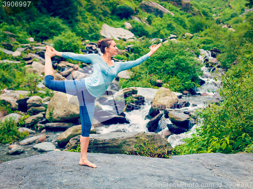 Image of Woman doing yoga asana Natarajasana outdoors at waterfall