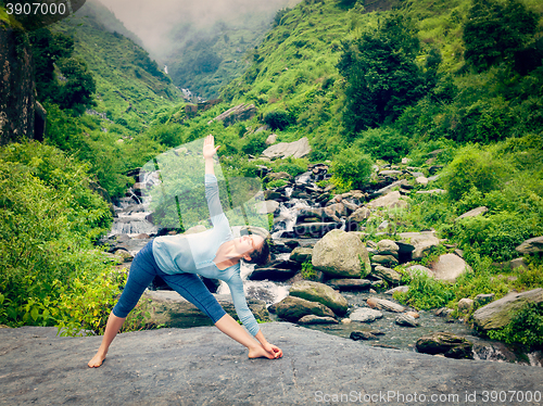 Image of Woman doing Ashtanga Vinyasa yoga asana Utthita trikonasana