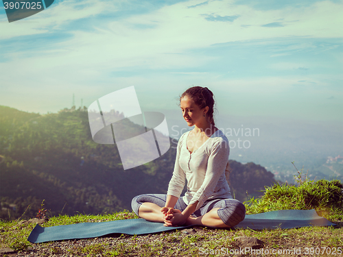 Image of Sporty fit woman practices yoga asana Baddha Konasana outdoors