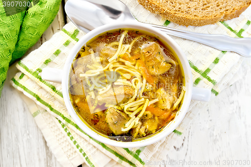 Image of Soup with mushrooms and noodles in bowl on napkin top