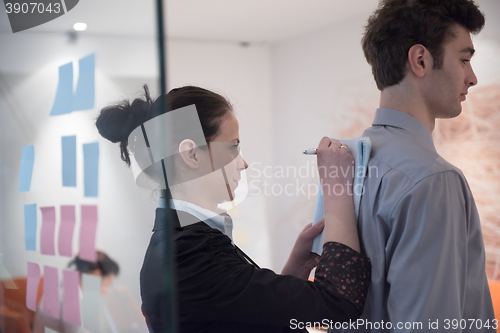 Image of young couple signing contract documents on partners back