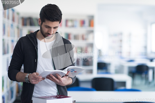 Image of portrait of student while reading book  in school library