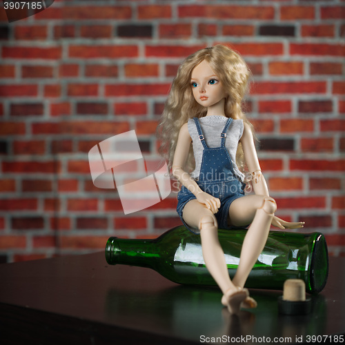 Image of doll with a bottle. the concept of alcoholism