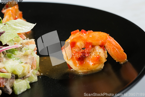 Image of perfect dish with shrimps on a black plate. seafood