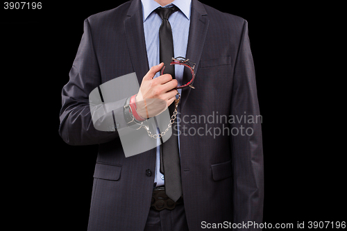 Image of man in a business suit with leather bound. handcuffs. sex Toys