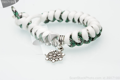 Image of green braided bracelet on white background. snowflake