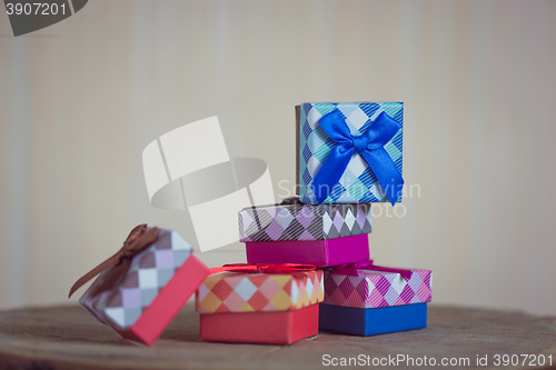 Image of Gift box with blue bow on wood background