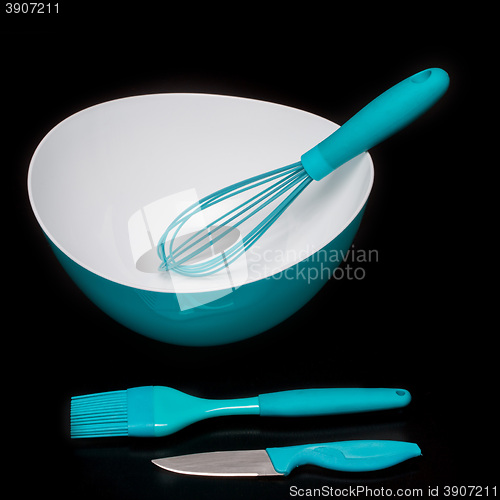 Image of Green silicone pastry brush and soup plate isolated on black