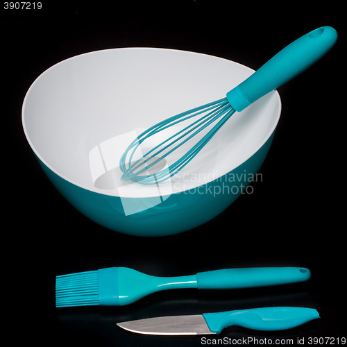 Image of Green silicone pastry brush and soup plate isolated on black